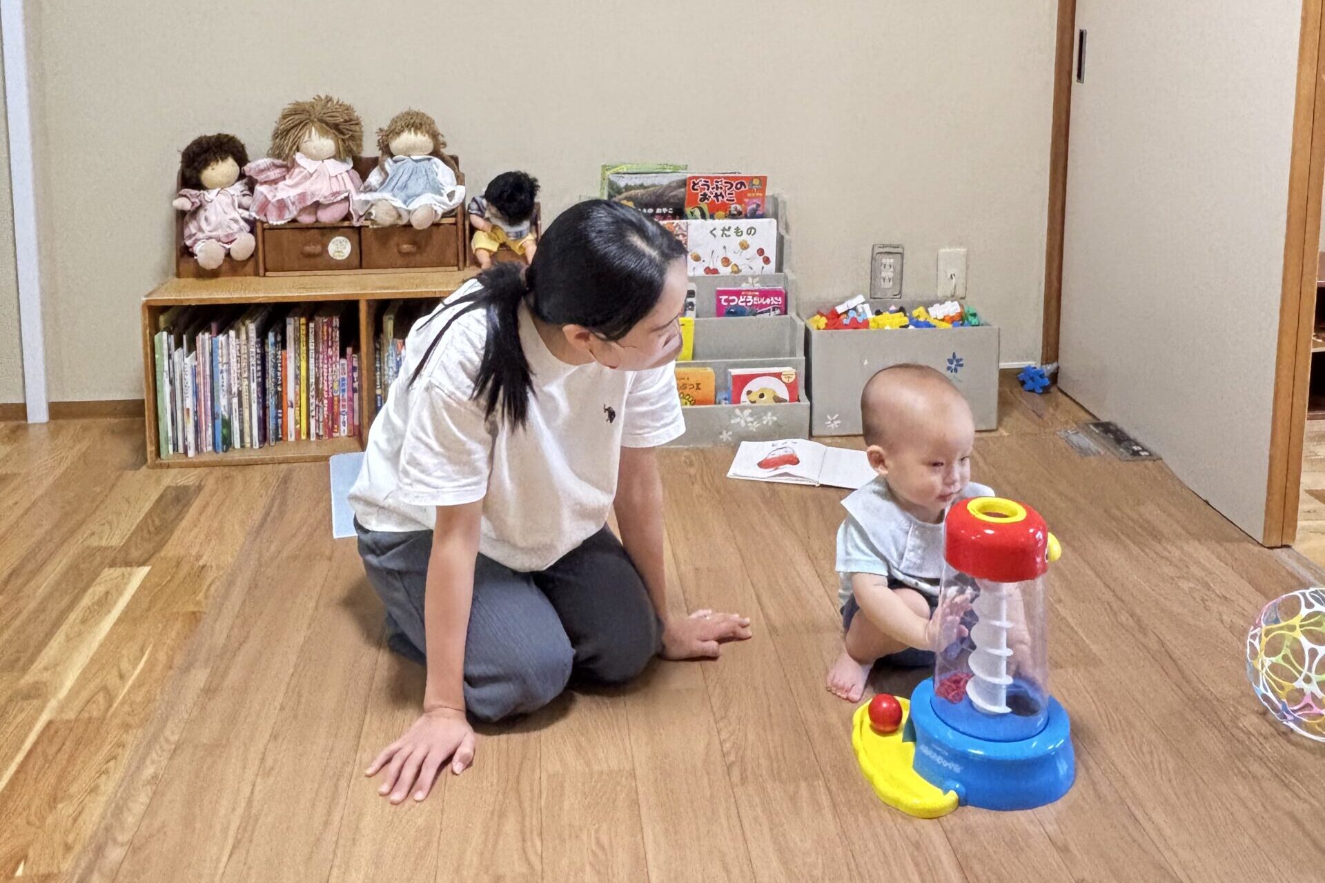 おもちゃで遊ぶ男の子と、それを見守る保育士の先生