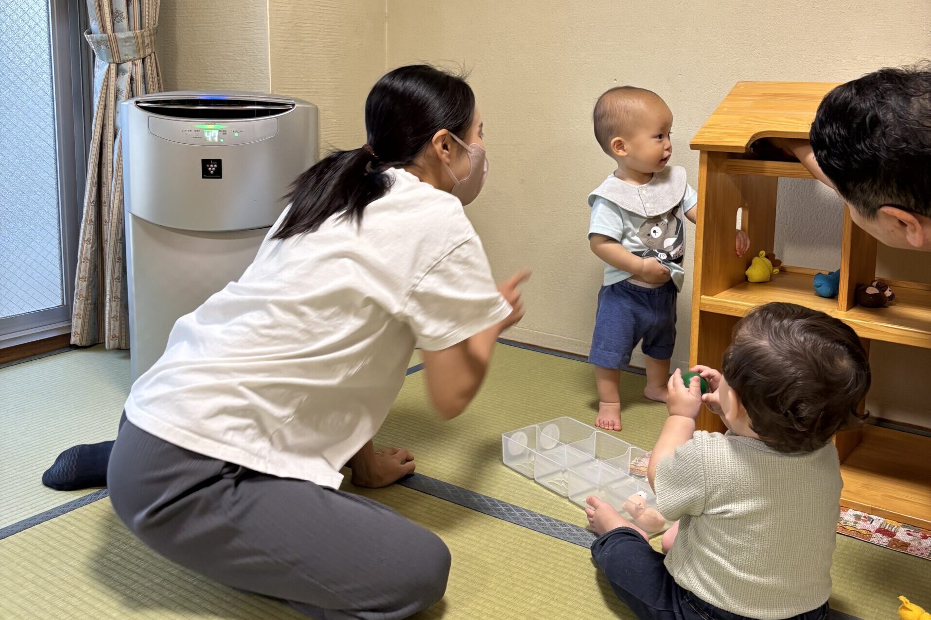 おもちゃで遊ぶ男の子と、それを見守る保育士の先生