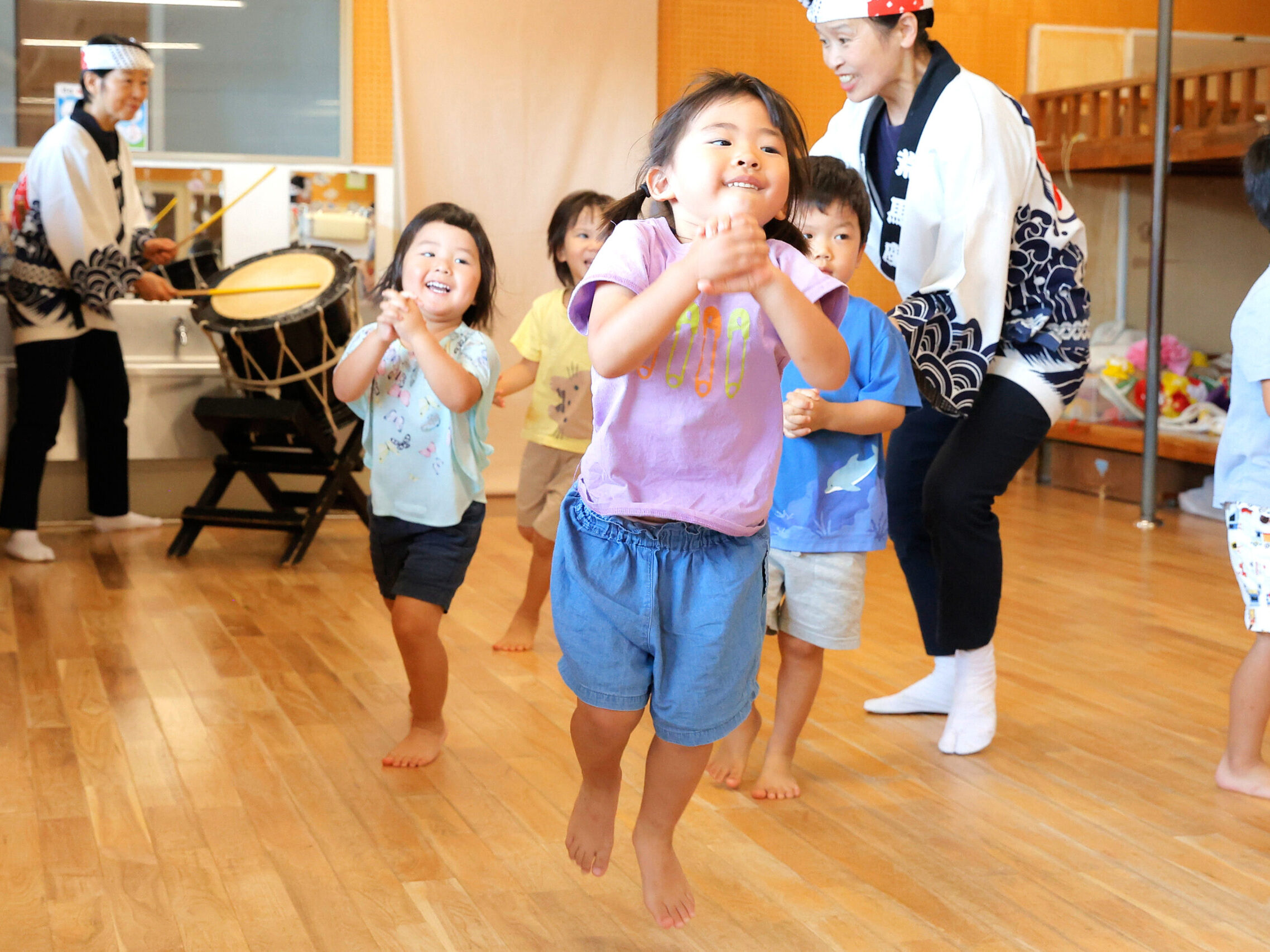 お部屋の中で先生に見守られながら走って遊ぶ子どもたち