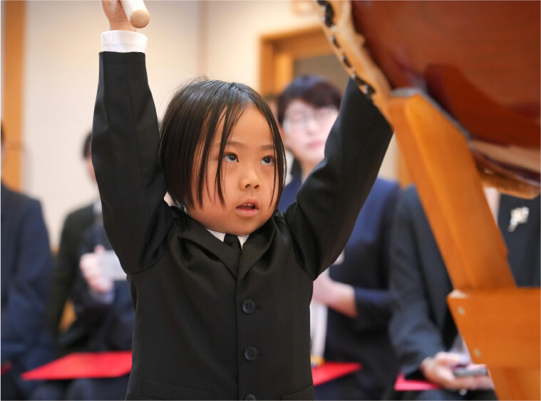 卒園の会で正装をして大太鼓を演奏する女の子