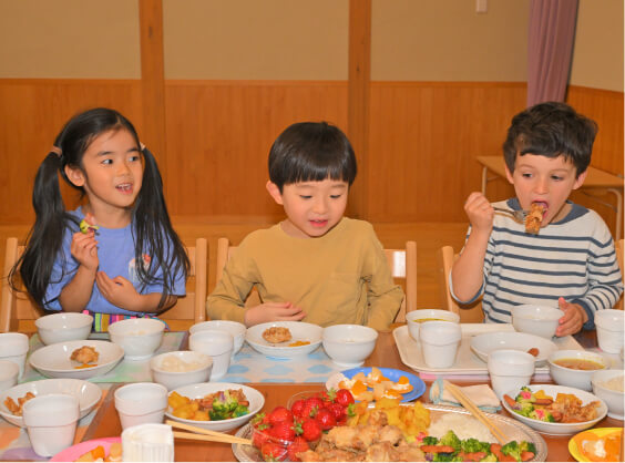 大皿に盛られた食事を美味しそうに食べる子どもたち