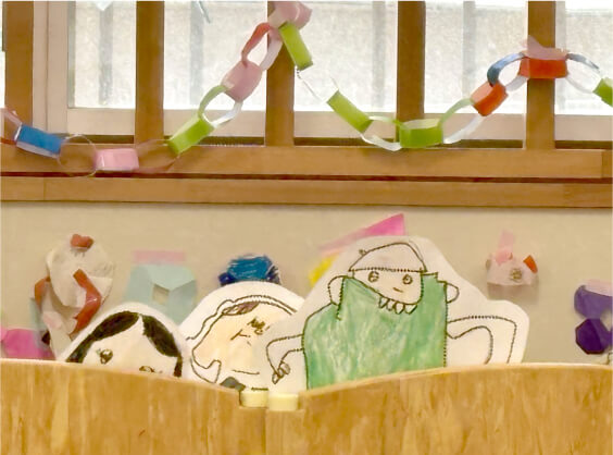 パーティーの飾り付けと子どもたちのイラストが展示された教室