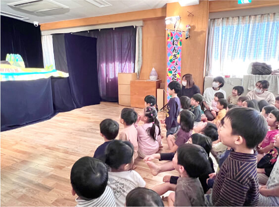 床に座り、演劇を興味深そうに見入る子どもたち