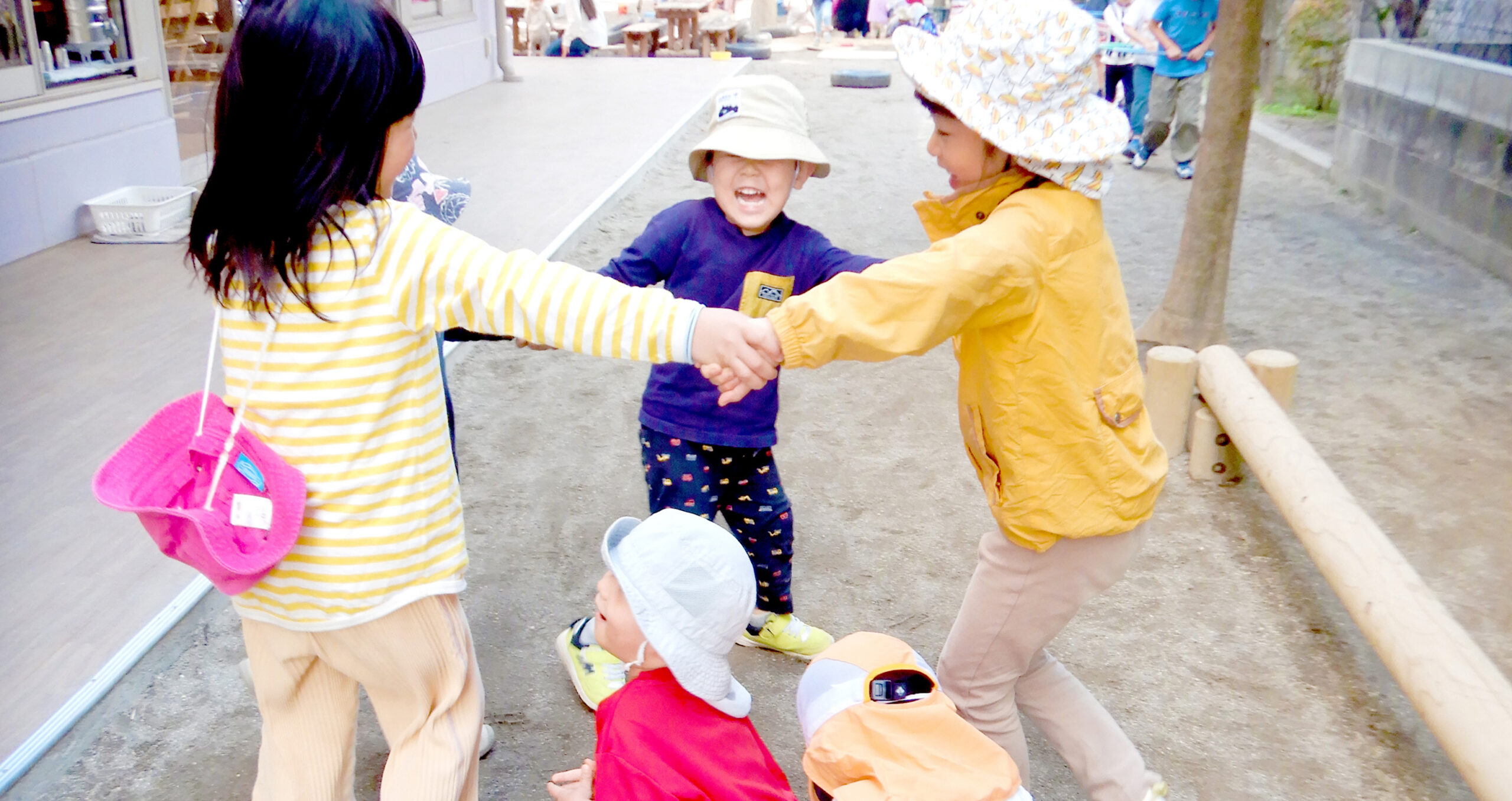 手を繋いでかごめかごめをする子供たち